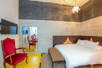 a bedroom with a bed and a chair and a mirror at Hotel Narcissus - Room 3 in San Diego