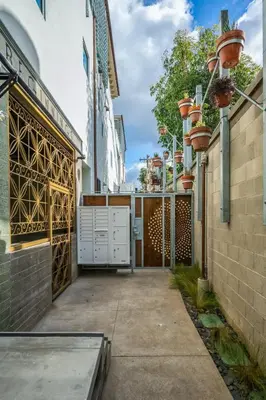 a courtyard of a building with a gate and flower pots at Hotel Narcissus - Room 3 in San Diego