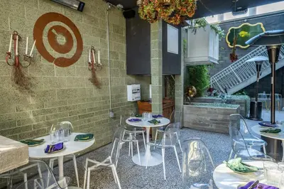 a restaurant with tables and chairs in front of a wall at Hotel Narcissus - Room 3 in San Diego