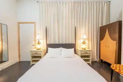a bedroom with a large white bed with two night stands at Hotel Narcissus - Room 4 in San Diego