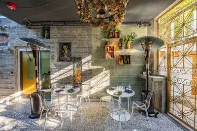 a dining room with two tables and chairs and a chandelier at Hotel Narcissus - Room 4 in San Diego