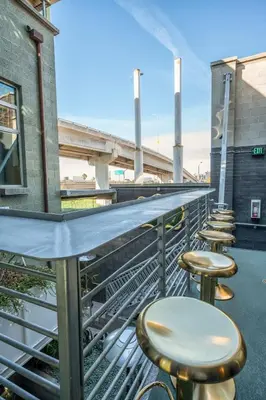 a row of stools on a balcony with a bridge at Hotel Narcissus - Room 4 in San Diego
