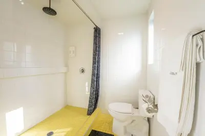 a white bathroom with a toilet and a shower at Hotel Narcissus - Room 5 in San Diego
