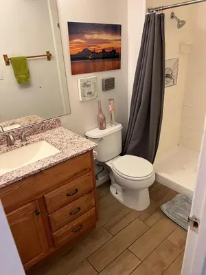 a bathroom with a toilet and a sink and a shower at Sunny Condo Steps from Sand in San Diego