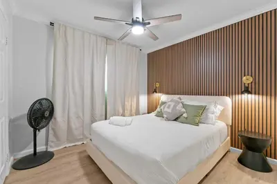 a bedroom with a white bed and a fan at Stylish Apartments in Mission Hills with Outdoor Space in San Diego