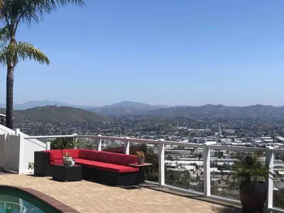 a red couch sitting on a balcony with a view at San Diego Paradise - Scenic Views, Pool and Spa in El Cajon