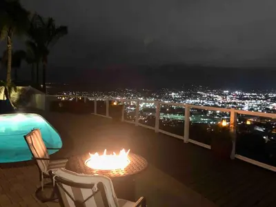 a balcony with a table and chairs and a city at night at San Diego Paradise - Scenic Views, Pool and Spa in El Cajon