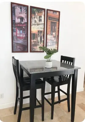 a black dining room table with two chairs and a potted plant at Corporate Housing, Vacation Rental in Irvine in Irvine