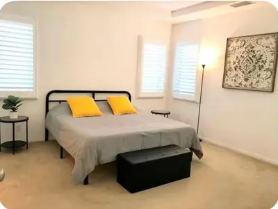 a bedroom with a bed with two yellow pillows at Corporate Housing, Vacation Rental in Irvine in Irvine