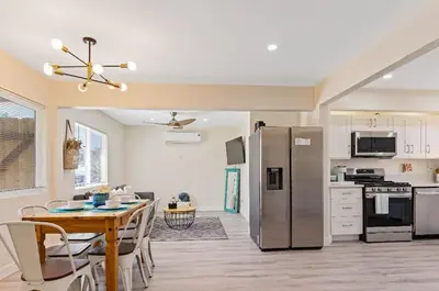 a kitchen and dining room with a table and a refrigerator at Sea & Sun Getaway near Seaworld in San Diego