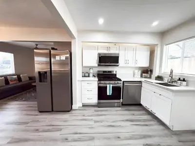 a kitchen with white cabinets and stainless steel appliances at Sea & Sun Getaway near Seaworld in San Diego