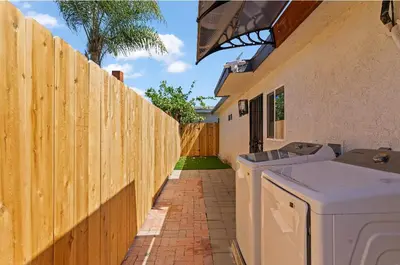 a house with a fence and a washing machine at Sea & Sun Getaway near Seaworld in San Diego