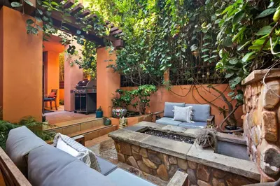 a patio with a couch and a stone wall at La Jolla Gem Ocean Views Walk to Village Beach in San Diego