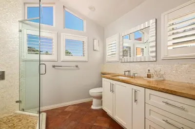a bathroom with a shower and a toilet and windows at La Jolla Gem Ocean Views Walk to Village Beach in San Diego