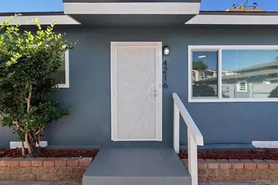 a blue house with a white door and stairs at Relaxing 3BR Getaway in Central SD in San Diego