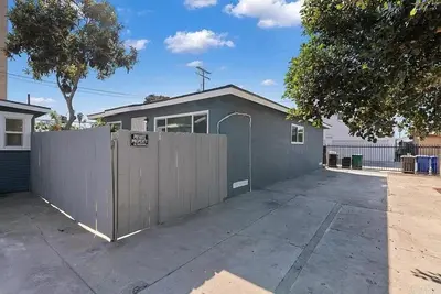 a house with a fence in front of a driveway at Relaxing 3BR Getaway in Central SD in San Diego