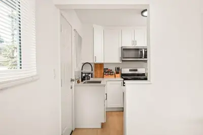 a white kitchen with white cabinets and a microwave at Relaxing 3BR Getaway in Central SD in San Diego