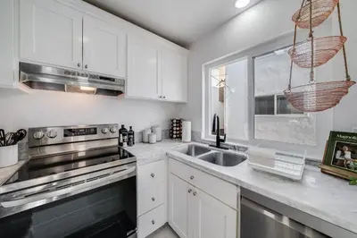 a kitchen with white cabinets and a sink at Jewell Street Gems Two homes in one in San Diego