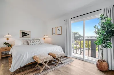 a bedroom with a bed and a large window at Jewell Street Gems Two homes in one in San Diego
