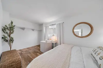 a white bedroom with a large bed and a mirror at Jewell Street Gems Two homes in one in San Diego