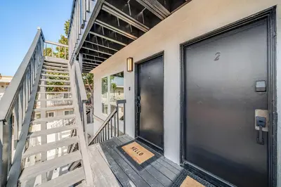 a staircase leading to a door with a sign on it at Jewell Street Gems Two homes in one in San Diego