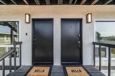 two black doors on the front of a house at Jewell Street Gems Two homes in one in San Diego
