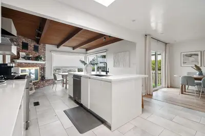 a kitchen with white countertops and a dining room at NEW Cozy Modern Home with Hot Tub and Ocean Views in San Diego