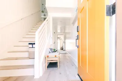 a hallway with stairs and a yellow door at Relaxing Mission Beach Getaway - 300ft to sand in San Diego