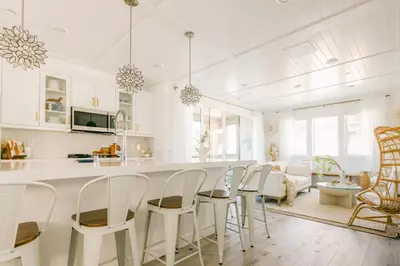 a white kitchen with white chairs and a kitchen island at Relaxing Mission Beach Getaway - 300ft to sand in San Diego