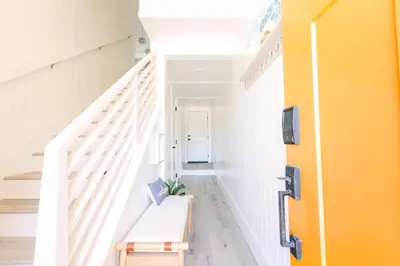 a hallway with a white staircase with a bench at Relaxing Mission Beach Getaway - 300ft to sand in San Diego