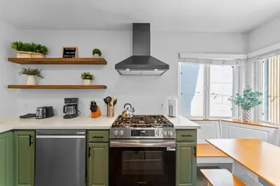 a kitchen with green cabinets and a stove top oven at Cozy San Diego Hideaway in Historic Mission Hills in San Diego