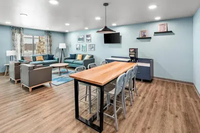 a living room with a table and chairs and a couch at WoodSpring Suites Santee - San Diego Northeast in Santee