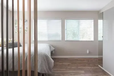 a bedroom with a bed and three windows at Modern Loft Retreat - North Park San Diego in San Diego