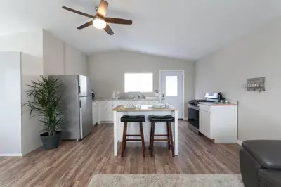 a kitchen with a refrigerator and a table with two stools at Modern Loft Retreat - North Park San Diego in San Diego