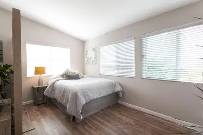 a bedroom with a bed and two windows at Modern Loft Retreat - North Park San Diego in San Diego