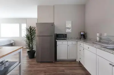 a kitchen with white cabinets and a refrigerator at Modern Loft Retreat - North Park San Diego in San Diego
