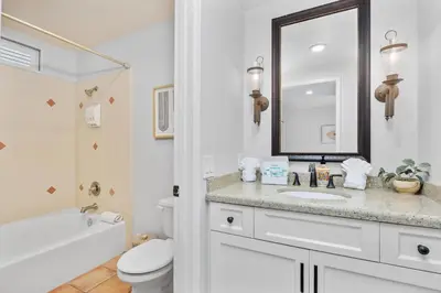 a bathroom with a sink and a toilet and a mirror at Top of the Wave - DMST31 in Solana Beach