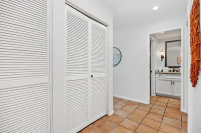 a hallway with white closet doors in a house at Top of the Wave - DMST31 in Solana Beach