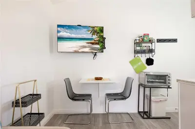 a dining room with a table and chairs and a microwave at Centra Spacious Villa in San Diego