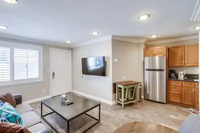 a living room with a couch and a kitchen at Mission Bay Getaway - Walk to the Water in San Diego