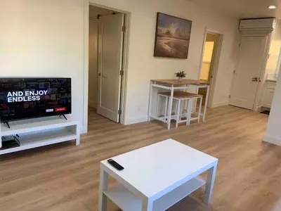 a living room with a tv and a white table at 2 Bedroom Modern North Park Gem in San Diego