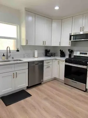 a kitchen with white cabinets and stainless steel appliances at 2 Bedroom Modern North Park Gem in San Diego