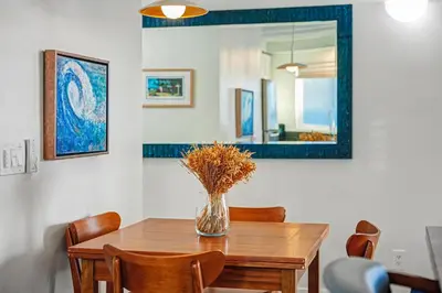 a dining room table with a vase of flowers on it at Mission Beach Gem - 1BR Near the Ocean in San Diego