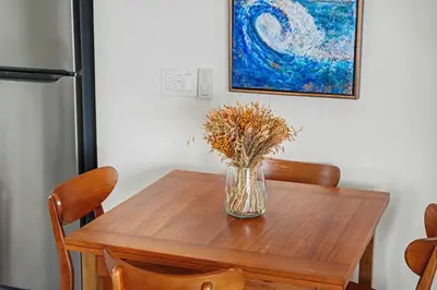 a wooden table with a vase of flowers on it at Mission Beach Gem - 1BR Near the Ocean in San Diego
