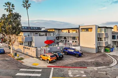 an apartment complex with cars parked in a parking lot at Mission Beach Gem - 1BR Near the Ocean in San Diego