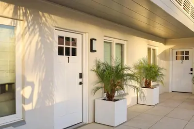 a house with two potted plants in front of a door at Work-From-Beach Dream Ocean Views Hot tub, BBQ in Oceanside