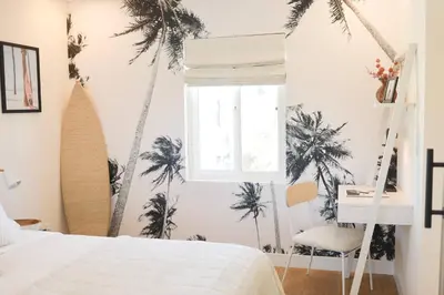 a bedroom with palm trees on the wall at The Swell Oceanview Designer Stay Hot Tub in Oceanside