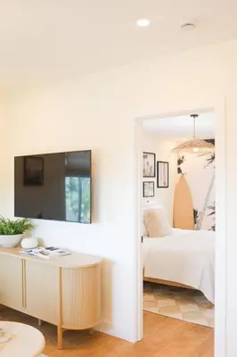 a bedroom with a bed and a table and a mirror at The Swell Oceanview Designer Stay Hot Tub in Oceanside
