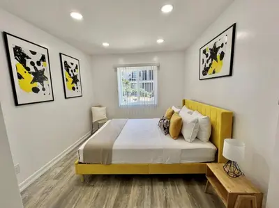 a bedroom with a large bed with a yellow headboard at 2-bedroom apartment Central San Diego! in San Diego