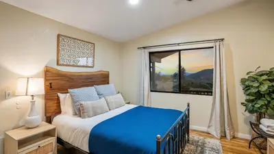 a bedroom with a blue bed and a window at Scenic Deck w Sunset Views Near Temecula Wineries Estrada Ranch by AvantStay in Fallbrook
